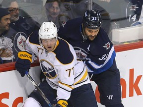 Buffalo Sabres defenceman Dmitry Kulikov (l) and Winnipeg Jets defenceman Dustin Byfuglien fight for the puck during NHL hockey in Winnipeg, Man. Sunday October 30, 2016. The pair are now teammates on the Jets blue-line. Brian Donogh/Winnipeg Sun/Postmedia Network