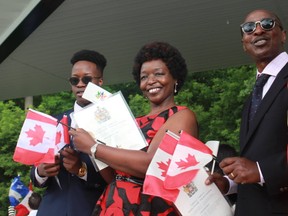 Rose Makini, her husband Lamack and son, Carlton, were all smiles as they became Canadian citizens on Canada Day (Shalu Mehta/The London Free Press).