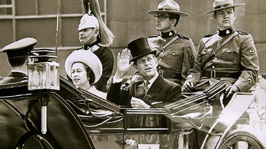 Queen Elizabeth II and Prince Philip ride in a horse-drawn landau past crowds lining University Ave. in Toronto, during their 1973 trip to Canada. (Postmedia Network File Photo)