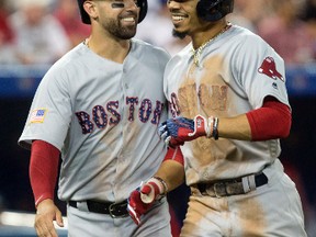 Boston Red Sox's Mookie Betts, right, is congratulated by Deven Marrero as he crosses home plate after hitting a two-run home run off Toronto Blue Jays starting pitcher Joe Biagini during sixth-inning baseball game action in Toronto, Sunday, July 2, 2017. (Chris Young/The Canadian Press via AP)