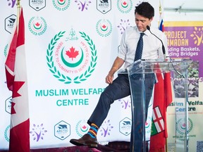 Prime Minister Justin Trudeau shows of his Ramadan color socks after helping prepare food baskets for Project Ramadan at the Muslim Welfare Centre in Scarborough, Ont., on Thursday, June 22, 2017. THE CANADIAN PRESS/Nathan Denette