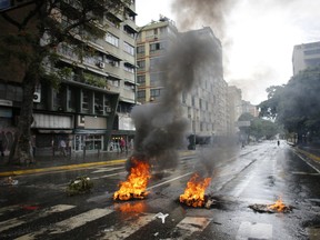 A burning barricade blocks a street in Caracas, Venezuela, Wednesday, June 28, 2017. The last 24 hours in Venezuela have been volatile, beginning with widespread looting in the coastal city of Maracay on Monday night and continued Tuesday with a police helicopter firing on Venezuela's Supreme Court and Interior Ministry while opposition lawmakers scuffled with security forces assigned to protect the National Assembly. (AP Photo/Ariana Cubillos)