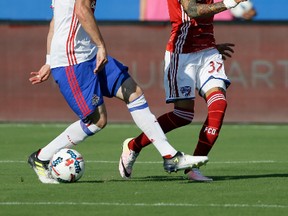 FC Dallas forward Maximiliano Urruti (37) makes a pass between the legs of Toronto FC defender Drew Moor for the assist on a Roland Lamah goal during the first half of an MLS soccer match, Saturday, July 1, 2017, in Frisco, Texas. (AP Photo/Tony Gutierrez)