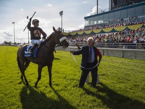 Magna International founder Frank Stronach leads Luis Contreras aboard "Holy Helena", after the Stronach Stables horse won the 158th running of the Queen's Plate horse race at Woodbine Race Track, in Toronto on Sunday, July 2, 2017. (THE CANADIAN PRESS/Mark Blinch)