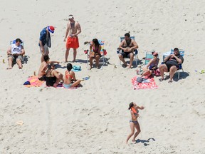 In this Sunday, July 2, 2017, photo, New Jersey Gov. Chris Christie, right, uses the beach with his family and friends at the governor's summer house at Island Beach State Park in New Jersey. Christie is defending his use of the beach, closed to the public during New Jersey's government shutdown, saying he had previously announced his vacation plans and the media had simply "caught a politician keeping his word." (Andrew Mills/NJ Advance Media via AP)