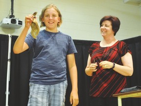 Brody Delude, 14, holds up the 10 inches of hair he had cut off June 28 during a special assembly in the gym of Champion School. Delude raised $6,000 for the Alberta Children’s Hospital for children’s cancer research and donated his hair to the Pantene Beautiful Lengths, a program that provides free, real-hair wigs for women with cancer. Stephen Tipper Vulcan Advocate