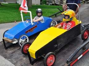 Nolan Rolph (left) and Ryan Glauser were two of five soap box derby racers to zoom down Swimming Pool hill Saturday morning, July 1. A large crowd lined the race route to cheer the thrills and (luckily no) spills of the racers. Nolan won the Colt Division (eight-to-12 year olds) and older brother Keith Rolph won the Mustang Division. ANDY BADER/MITCHELL ADVOCATE