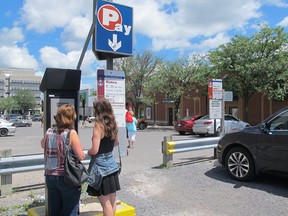 Customers line up to use a pay and display parking machine at the Drury Municipal Parking Lot in downtown Kingston on Monday, July 3, 2017, a practise that may become outdated with the introduction of mobile payment options. Ashley Rhamey for the Whig-Standard/Postmedia Network