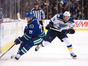 St. Louis Blues right wing Ty Rattie (18) fights for control of the puck with Vancouver Canucks defenseman Alexander Edler (23) during first period NHL action in Vancouver on Oct. 18, 2016.