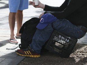 A panhandler at the corner of  Yorkville Ave, and Bay St. on Monday. (VERONICA HENRI, Toronto Sun)