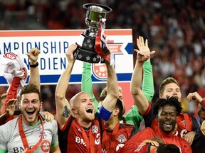 TFC"s Michael Bradley hoists the Voyageurs Cup after defeating Montreal last week. (THE CANADIAN PRESS)