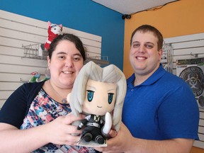 Joelle Lavoie and Moe Charette, co-owners of Mojoverse, show off their mascot Sephiroth on Monday. The store store will be going to an online-only format. (Gino Donato/Sudbury Star)