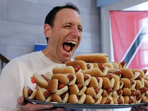 Current men’s champion Joey Chestnut, of San Jose, Calif., holds a tray of hot dogs during the weigh-in for the 2017 Nathan’s Hot Dog Eating Contest, in Brooklyn Borough Hall, in New York, Monday, July 3, 2017. (AP Photo/Richard Drew)