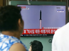 People watch a TV news program showing a file image of a missile being test-launched by North Korea, at the Seoul Railway Station in Seoul, South Korea, Tuesday, July 4, 2017. North Korea on Tuesday launched yet another ballistic missile in the direction of Japan, South Korean officials said, part of a string of recent test-firings as the North works to build a nuclear-tipped missile that could reach the United States. The signs read "North Korea launched a missile." (AP Photo/Ahn Young-joon)