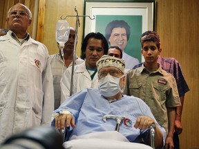 In this Wednesday, Sept. 9, 2009 file photo Libyan Abdelbaset al-Megrahi, is seen below a portrait of Libyan Leader Moammar Gadhafi, at Tripoli Medical Center in Tripoli, Libya.(AP Photo/Abdel Magid Al Fergany, File)
