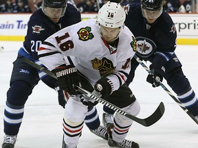 Chicago Blackhawks centre Marcus Kruger battles for a loose puck with Winnipeg Jets forwards during NHL action at MTS Centre in Winnipeg on March 29, 2015. (Kevin King/Winnipeg Sun)