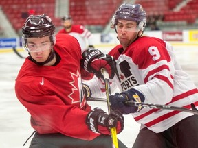 Queen’s defenceman Spencer Abraham, right, of the Canadian University All-Stars checks Nicolas Roy of the Team Canada juniors during exhibition hockey action on Dec. 13 in Boisbriand, Que. (Ryan Remiorz/The Canadian Press)