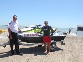 Fire chief Chris McDonough, left, and beach patrol captain Greg Howard stand beside the new rescue watercraft that Central Elgin fire services acquired recently. (Laura Broadley/Times-Journal)