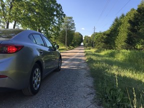 This driver stares down magnetic hill on Centennial Road west of Sparta, an optical illusion that makes it seem like the car is sliding backwards uphill when its in neutral. The unusual slope attracts passersby every summer, but it’s also attracting attention from the Municipality of Central Elgin and Elgin OPP too. (Jennifer Bieman/Times-Journal)