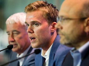 Oilers Entertainment Group Vice Chair and CEO Bob Nicholson, Connor McDavid, and President of Hockey Operations & General Manager Peter Chiarelli take part in a press conference at Rogers Place, where it was announced that McDavid has signed an eight-year contract worth $12.5 million a year with the Edmonton Oilers, in Edmonton Wednesday July 5, 2017.