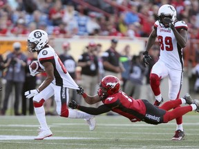 Calgary Stampeders' Ciante Evans tries to tackle Ottawa Redblacks' Diontae Spencer in CFL action in Calgary on June 29, 2017. (THE CANADIAN PRESS/Mike Ridewood)