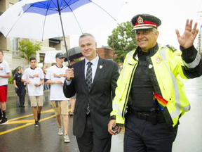 Matt Skof, president of the Ottawa Police Association, and Ottawa police Chief Charles Bordeleau make their way along the parade route during Capital Pride's 2016 parade. ASHLEY FRASER / OTTAWA CITIZEN