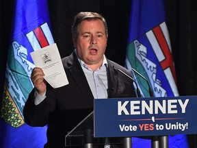 PC Alberta Leader, Jason Kenney, holds up the United Conservative Party agreement in principle  while speaking to supporters about the upcoming vote on unity between the PCs and Wildrose, at the Delta South Hotel in Edmonton, July 5, 2017.