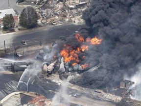 Smoke rises from railway cars that were carrying crude oil after derailing in downtown Lac-Megantic, Que., on July 6, 2013. THE CANADIAN PRESS/Paul Chiasson