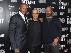 In this June 27, 2017, file photo, music mogul Jimmy Iovine, centre, poses with rapper Dr. Dre, left, and producer Allen Hughes at the premiere of HBO's "The Defiant Ones" at the Time Warner Center in New York. The four-part documentary series tracks the lives of Iovine and Dre, and their unlikely partnership turning out hit records and creating Beats headphones, which they sold to Apple in 2014. (Photo by Evan Agostini/Invision/AP, File)