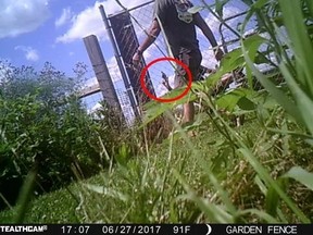 Security camera footage shows a man riding a lawn mower holding a handgun in the air before a shootout occurs between two neighbours in Johnson County on June 27, 2017. (Johnson County Prosecutor's Office)