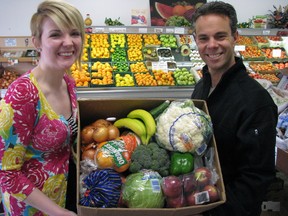 Simone Edginton with Lambton Public Health and Sarnia Produce's Dean Troiani, in this 2011 file photo, hold a sample of fresh vegetables and fruit provided through Lambton County's Garden Fresh Box program. Lambton Public Health announced recently it's cheaper to get fruits and vegetables through the program than to buy directly from grocery stores. (File photo)