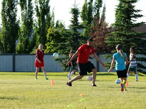 Photo by Keenan Sorokan Reporter/Examiner 
FC Edmonton academy players lead some budding young minor soccer players at Longview Park on Tuesday night. The team has teamed up with AMA to provide free clinics across the province. Another round of clnics in Stony Plain are set for Augsut 1-2.