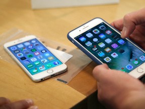 In this Friday, Sept. 16, 2016, file photo, a customer sets up his new iPhone 7 Plus, right, as he switches from the iPhone 6 at the Apple Store on Michigan Avenue during the release of the Apple iPhone 7 and the latest Apple Watches, in Chicago. (AP Photo/Kiichiro Sato, File)