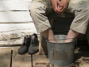 1885 Historical Interpreters Cedric Reimer cools his heels in a bucket of water at Fort Edmonton Park, in Edmonton Thursday July 6, 2017. David Bloom/Edmonton Sun