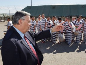 In this Feb. 4, 2009, file photo, Maricopa County Sheriff Joe Arpaio, left, orders approximately 200 convicted illegal immigrants handcuffed together and moved into a separate area of Tent City in Phoenix. (AP Photo/Ross D. Franklin, File)