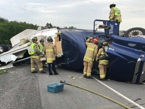 Firefighters work on cleaning up spills following a truck rollover on Highway 417 Friday. OTTAWA PARAMEDIC SERVICE / VIA TWITTER