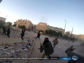 This photo posted on a file sharing website Wednesday, Jan. 11, 2017, by the Islamic State Group in Sinai, a militant organization, shows a deadly attack by militants on an Egyptian police checkpoint, in el-Arish, north Sinai, Egypt. The officials say the Friday, July 7, 2017 attack started when a suicide car bomber rammed his vehicle into the checkpoint in southern Rafah village of el-Barth, followed by heavy shooting by dozens of masked militants on foot. (Islamic State Group in Sinai via AP, File)