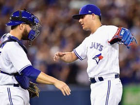 Toronto Blue Jays relief pitcher Roberto Osuna celebrates with catcher Russell Martin after closing out the ninth inning of an MLB game against the Houston Astros in Toronto on July 6, 2017. (THE CANADIAN PRESS/Frank Gunn)
