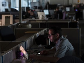 Reporters and photographers at the Postmedia building in downtown Edmonton continued to work in the dark after a power outage struck parts of the city in the middle of the afternoon on July 7, 2017.