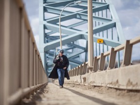 Danny Pilkafski carries his guitar over the Peace River bridge on thursday May 1, 2014. ADAM DIETRICH/RECORD-GAZETTE/QMI AGENCY