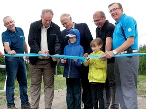 A new Trans Canada Trail Extension, approximately 27 km of on and off-road trails between Tillsonburg and Delhi, was officially opened last Thursday in Tillsonburg with a ribbon cutting ceremony. From left are Jim Paterson, Trails Canada - Trail Ontario; Tillsonburg's Rick Cox, Director of Recreation, Culture and Parks; David Mayberry, Oxford County Warden; Oxford MPP Ernie Hardeman; Frank Gross, Manager of Transportation and Waste, Oxford; and Tillsonburg Mayor Stephen Molnar, with two young visitors from Nova Scotia. (Chris Abbott/Tillsonburg News)