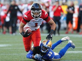 Calgary Stampeders’ Lemar Durant gets stopped by Blue Bombers’ TJ Heath in Winnipeg last night. (The Canadian Press)