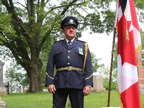 Mike Ryan, Correctional Service Canada deputy regional director Ontario Region, stands next to the gravesite of Henry Traill, the first prison guard in Canada killed in the line of duty, after a memorial ceremony for fallen CSC workers at Cataraqui Cemetery on Friday.