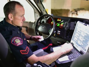 Constable Ian Vernon, a member of the Calgary police BEAT unit, uses his cruiser's mobile work station (MWS) to run the name of a suspect through CPIC in Calgary, Alta. on Wednesday, June 28 2017. Bryan Passifiume/Postmedia Network