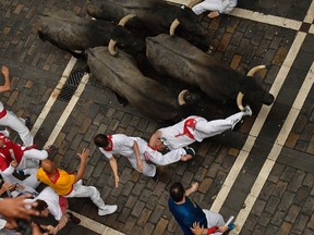 A revellers falls in front of Jose Escolar fighting bulls during the second running of the bulls at the San Fermin Festival, in Pamplona, northern Spain, Saturday, July 8, 2017. Revellers from around the world flock to Pamplona every year to take part in the eight days of the running of the bulls. (AP Photo/Alvaro Barrientos)