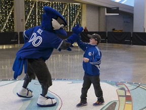 Charlie Winegarden, 9, (centre), high fives Blue Jays mascot Ace before meeting Toronto Blue Jays players Kevin Pillar, Devon Travis, Aaron Sanchez and Marco Estrada with his family including father Charles (right) during a Blue Jays 2017 Winter Tour stop at Rogers Place in Edmonton, Alberta on Friday, January 13, 2017. Ian Kucerak / Postmedia