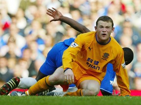 In this Saturday, April 17, 2004 file photo, Chelsea's Geremi (behind) falls as Everton's Wayne Rooney appeals for a foul, during their English Premier League soccer match at Chelsea's Stamford Bridge ground in west London. Wayne Rooney has left Manchester United to rejoin Everton after 13 years at Old Trafford, it was announced on Sunday, July 9, 2017. Everton says Rooney signed a two-year contract.(AP Photo/Alastair Grant, file)