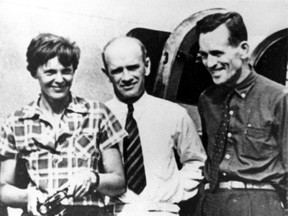 In this file photo taken on or about July 2, 1937, American aviator Amelia Earhart, left, and her navigator, Fred Noonan, right, pose beside their plane with gold miner F.C. Jacobs at Lae, New Guinea just before Earhart and Noonan took off in a flight to Howland Island on July 2, during which they disappeared somewhere in the Pacific. (AP Photo, File)