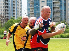 Belleville Bulldogs ballcarrier John Nelles is grabbed by a Kingston Panthers defender during over-35's Old Boys rugby competition last weekend in Kingston as part of the Panthers' 50th anniversary celebrations. (Submitted photo)