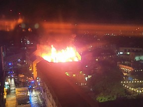 Flames and smoke rise from a fire affecting a small area of Camden Market in London early Monday July 10, 2017. Dozens of firefighters poured water onto a big fire early Monday at Camden Lock Market, which is a popular tourist destination in north London. (AP Photo/Mike Buckell)